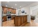 Kitchen with stainless steel appliances, dark cabinets, and a bar area with hardwood floors and recessed lighting at 2605 Fort Apachee Trl, Dacula, GA 30019