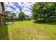 Expansive backyard featuring lush green grass and mature trees with a patio area, perfect for outdoor activities at 2870 Tattersall Ct, Cumming, GA 30041
