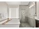 Bathroom featuring a soaking tub, glass-enclosed shower with tile, and modern fixtures at 2870 Tattersall Ct, Cumming, GA 30041