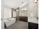 Bathroom featuring a soaking tub, glass-enclosed shower, dual vanities, and modern fixtures at 2870 Tattersall Ct, Cumming, GA 30041