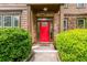 Inviting front entrance with a striking red door and stone accents framed by lush greenery at 2870 Tattersall Ct, Cumming, GA 30041