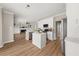 Open-concept kitchen seamlessly connected to a living room with a fireplace, offering modern appliances and design at 2870 Tattersall Ct, Cumming, GA 30041