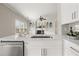 Bright kitchen featuring white cabinets, quartz countertops, stainless steel appliances, and a view into the living area at 2870 Tattersall Ct, Cumming, GA 30041