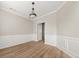 Living room with wainscotting, modern lighting, hardwood floors, and neutral paint colors at 2870 Tattersall Ct, Cumming, GA 30041