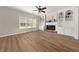 Cozy living room featuring a fireplace flanked by built-in shelves, large windows, and hardwood floors at 2870 Tattersall Ct, Cumming, GA 30041