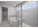 Contemporary bathroom with a glass-enclosed shower, soaking tub, and tiled walls at 120 Aj Welch Jr Way, Mcdonough, GA 30252