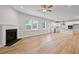Open concept living area with a fireplace, hardwood floors, and an adjacent modern kitchen at 120 Aj Welch Jr Way, Mcdonough, GA 30252