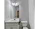 Well-lit bathroom features a pristine white vanity, a large mirror, and a toilet, offering a clean, modern look at 3360 Pickens St, Duluth, GA 30096