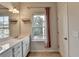 Well-lit bathroom featuring double vanity, and large mirror with natural light from window at 3360 Pickens St, Duluth, GA 30096