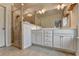 Well-lit bathroom featuring a double vanity, large mirror, and a tiled shower with glass door at 3360 Pickens St, Duluth, GA 30096