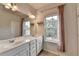 Bright bathroom featuring a double vanity, large mirror and a window providing natural light at 3360 Pickens St, Duluth, GA 30096