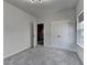 Bright bedroom featuring plush gray carpet, a window, and double doors, creating a welcoming and functional space at 3360 Pickens St, Duluth, GA 30096