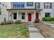 Exterior view of the townhouse with a red door, front porch and beautifully manicured front lawn at 3360 Pickens St, Duluth, GA 30096