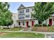 Charming townhome featuring a well-maintained lawn, brick facade, dark shutters and a red front door at 3360 Pickens St, Duluth, GA 30096