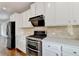 Modern kitchen features stainless steel appliances, beautiful countertops, and sleek white cabinets at 3360 Pickens St, Duluth, GA 30096