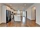 Open kitchen with stainless steel appliances, white cabinets, and a large center island at 3360 Pickens St, Duluth, GA 30096