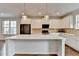 Kitchen featuring an island, white cabinets, stainless steel appliances, and hardwood floors at 3360 Pickens St, Duluth, GA 30096