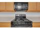 A gas range with a microwave is surrounded by wooden cabinets and white countertops at 7459 Old Chapel, South Fulton, GA 30349