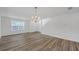 Bright living room featuring hardwood floors, a modern chandelier, and large windows for natural light at 7459 Old Chapel, South Fulton, GA 30349