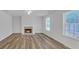 Cozy living room featuring a fireplace, hardwood floors, and plenty of natural light from the windows at 7459 Old Chapel, South Fulton, GA 30349
