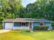 Front exterior view of a blue home with a white garage door, red shutters, and a landscaped front yard at 1183 Iron Gate Blvd, Jonesboro, GA 30238