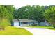 Single-story home with a well-manicured lawn, spacious driveway and mature shade trees at 1183 Iron Gate Blvd, Jonesboro, GA 30238