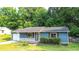 Charming single-story home with a well-manicured lawn, blue siding, and a cozy front porch at 1183 Iron Gate Blvd, Jonesboro, GA 30238