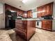 Well-lit kitchen featuring matching wood cabinets and a center island with tile flooring at 1183 Iron Gate Blvd, Jonesboro, GA 30238