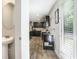 View of kitchen featuring dark cabinetry and granite countertops from hallway entrance at 12225 Anchor Way, Hampton, GA 30228