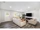 Bright living room featuring hardwood floors, large windows, and modern furnishings at 12225 Anchor Way, Hampton, GA 30228