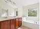 Bathroom with soaking tub, double vanity, and natural light at 626 Pecan Knoll Dr # 13, Marietta, GA 30008