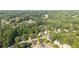 A sunny aerial view captures a lush residential neighborhood, surrounded by mature trees and winding roads at 9310 Chapelwood Dr, Johns Creek, GA 30022