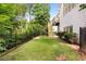 Spacious backyard features a lush green lawn and a black iron fence, perfect for outdoor activities at 9310 Chapelwood Dr, Johns Creek, GA 30022