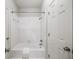 Bright white bathroom featuring a tub/shower combo with white tile and white hexagon tile floors at 9310 Chapelwood Dr, Johns Creek, GA 30022