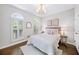 Bright bedroom with hardwood floors, neutral decor, and arched windows with plantation shutters at 9310 Chapelwood Dr, Johns Creek, GA 30022