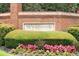 A brick-clad Wynbrook community welcome sign is surrounded by colorful flowers and greenery at 9310 Chapelwood Dr, Johns Creek, GA 30022