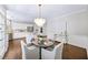 Charming dining room with a chandelier, table set for four, and view to the kitchen at 9310 Chapelwood Dr, Johns Creek, GA 30022