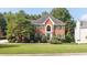 Charming brick two-story home with manicured lawn and mature trees showcasing classic curb appeal at 9310 Chapelwood Dr, Johns Creek, GA 30022