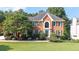 Charming brick two-story home with manicured lawn and mature trees showcasing classic curb appeal at 9310 Chapelwood Dr, Johns Creek, GA 30022