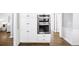 Gourmet kitchen with stainless double ovens and designer white cabinets at 9310 Chapelwood Dr, Johns Creek, GA 30022