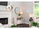 Cozy living room features a fireplace, console table with decor, and large bright window at 9310 Chapelwood Dr, Johns Creek, GA 30022