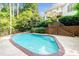 Private backyard pool with brick trim, wooden staircase, and lush landscaping at 9310 Chapelwood Dr, Johns Creek, GA 30022