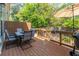 Back deck features an outdoor dining set, an umbrella, string lights, and a gas grill at 1382 Doublegate Ne Dr, Atlanta, GA 30319