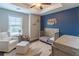Charming Bedroom featuring a crib, chair, a dark accent wall, and a ceiling fan at 1382 Doublegate Ne Dr, Atlanta, GA 30319