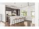 Open kitchen with an island with seating, stainless steel appliances, modern lighting and hardwood floors at 19 Moda Ln, Atlanta, GA 30316
