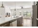 Modern kitchen island with stainless appliances flowing into a bright, open living space with hardwood floors and modern fixtures at 19 Moda Ln, Atlanta, GA 30316