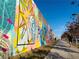 A vibrant public art wall with colorful murals and sidewalk pathway at 19 Moda Ln, Atlanta, GA 30316