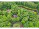 Aerial view of a home and neighborhood with a pond, surrounded by lush greenery and mature trees at 4800 Timberland Sw Dr, Mableton, GA 30126