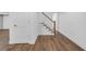 Basement hallway features vinyl flooring, a staircase, and a white painted door with gold hardware at 4800 Timberland Sw Dr, Mableton, GA 30126