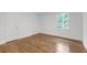 Bright bedroom featuring hardwood floors, white walls, and a window offering natural light at 4800 Timberland Sw Dr, Mableton, GA 30126